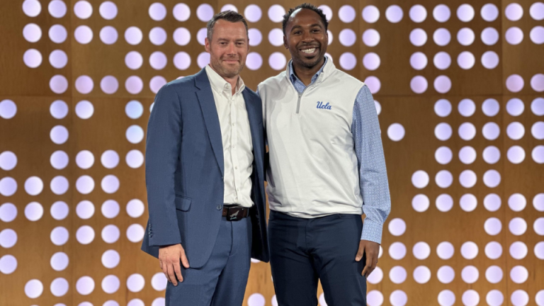 Patrick Jeffs speaking on stage with a colleague