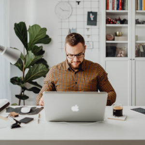 Man working on a laptop at a home office desk